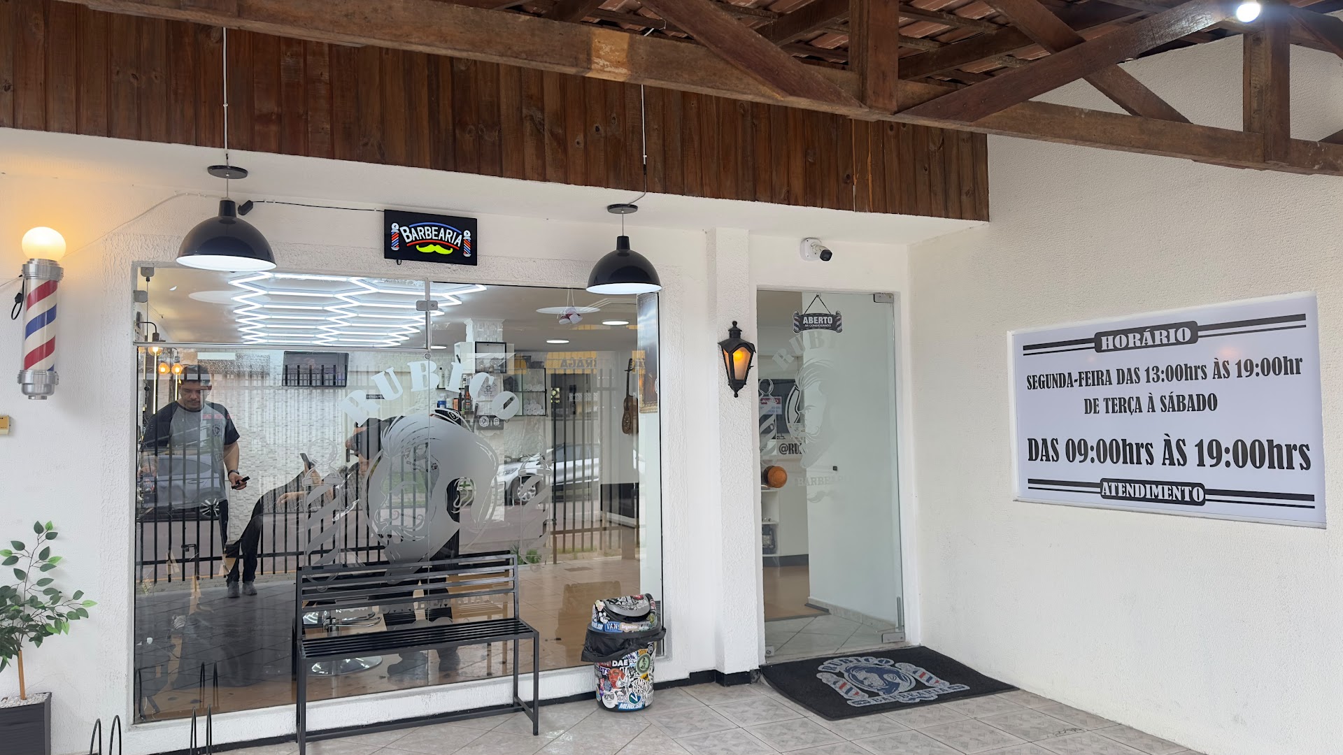 Entrada da Rubico Barber Shop, com o horário de atendimento na parede